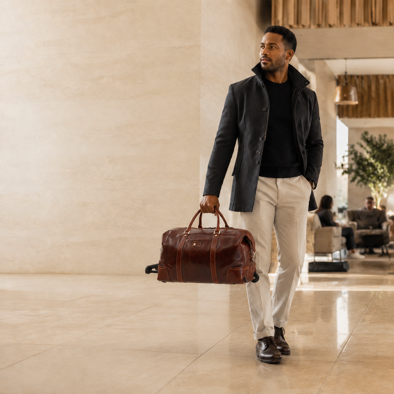 Traveller carrying the Jekyll and Hide Oxford Cabin Wheeled Holdall 3690 by its leather handles