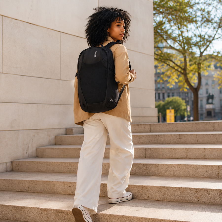 Woman wearing the Thule EnRoute Backpack 26L in black on city steps